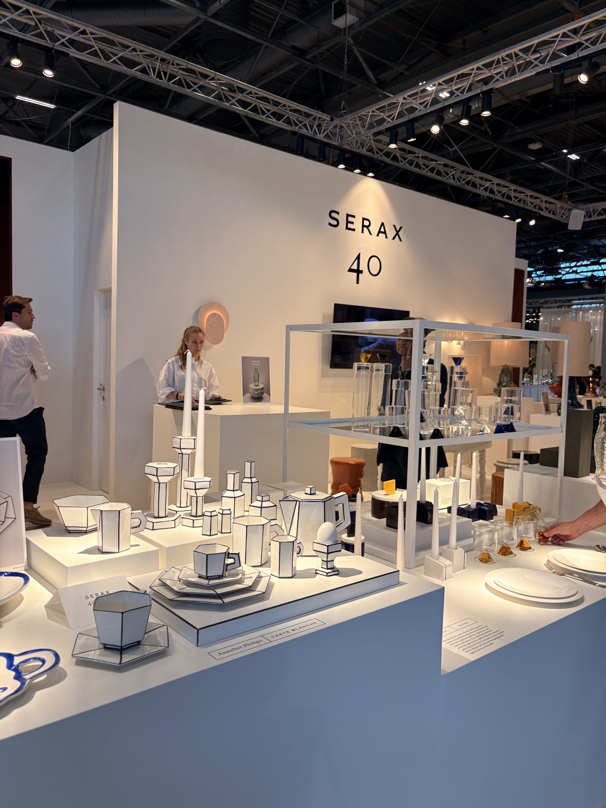 Serax 的白色攤位,牆上寫著 SERAX 40,展台上擺著黑線勾邊、像手繪線稿的白瓷餐具